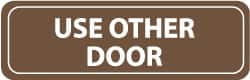 NMC - Use Other Door, 11" Wide x 3.5" High, Acrylic Sign - English, White on Brown, Wall Mount - Benchmark Tooling