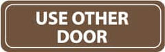 NMC - Use Other Door, 11" Wide x 3.5" High, Acrylic Sign - English, White on Brown, Wall Mount - Benchmark Tooling